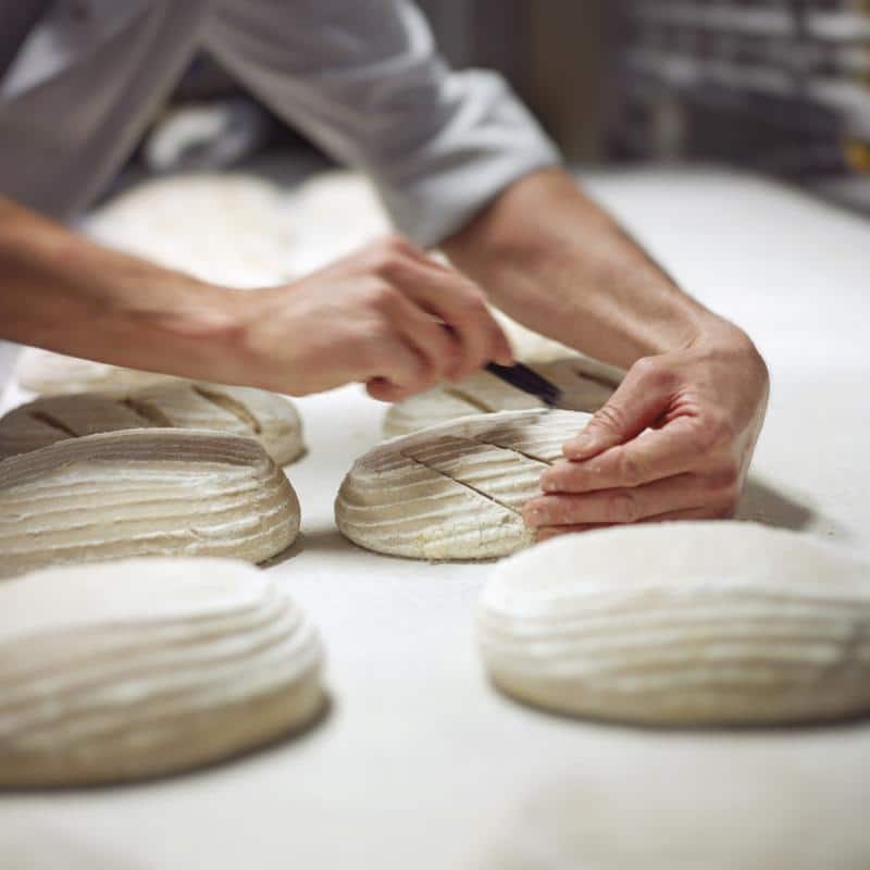 Image d'illustration représentant un boulanger qui pétrit de la pâte à pain